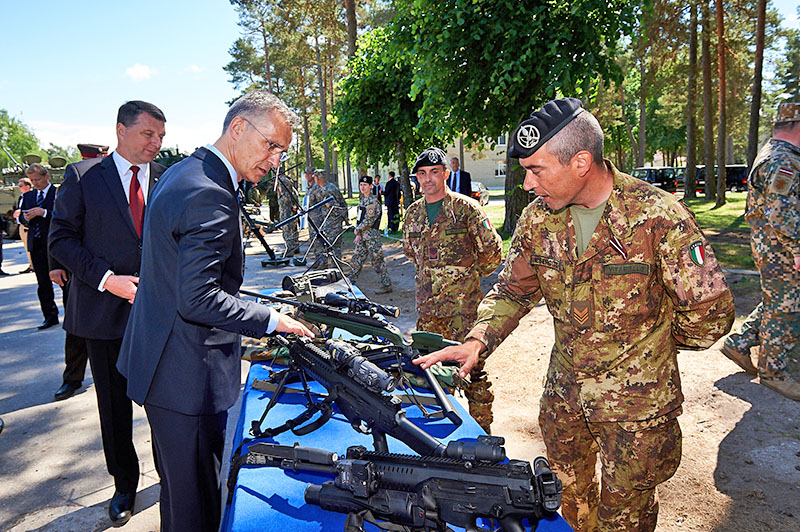 Президент Латвии Раймонд Вейонис и Йенс Столтенберг осматривают оружие итальянских военных.