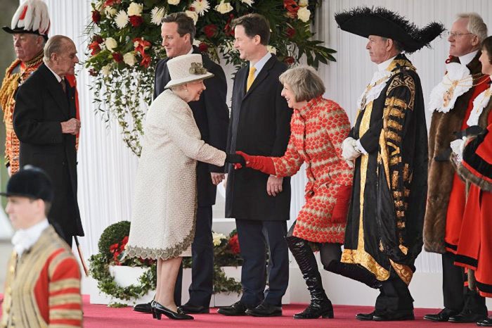 Модница Мэй щеголяла перед королевой в лакированных ботфортах.