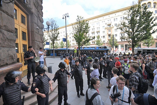 Участники несанкционированной акции в поддержку кандидатов в депутаты Мосгордумы и полиция у здания мэрии Москвы.