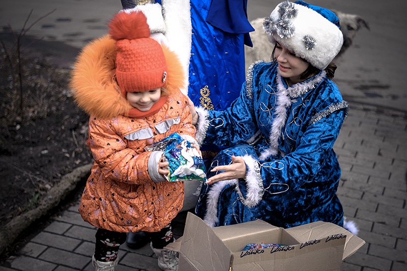 Снегурочка в прифронтовом районе раздает подарки.