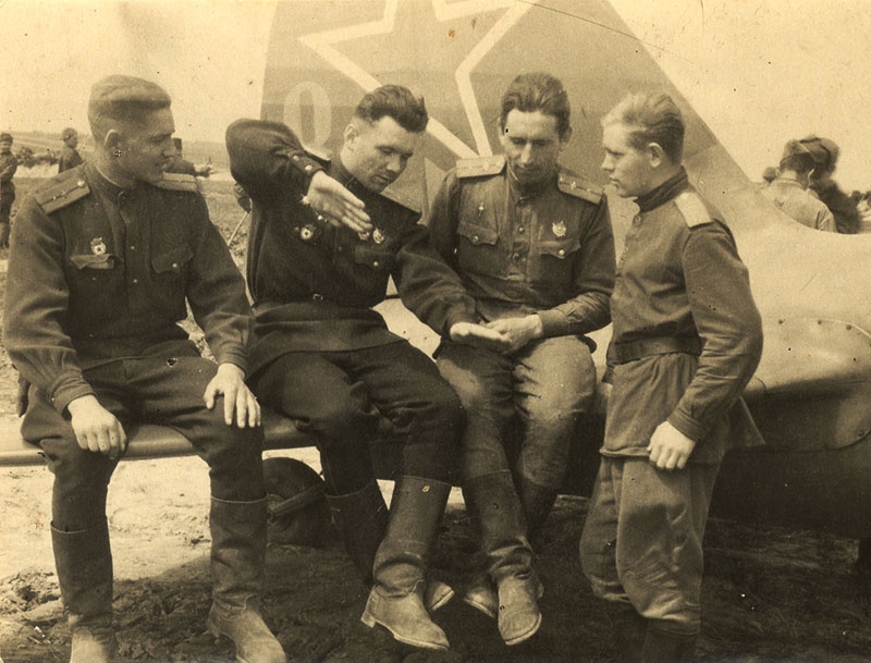 Командир эскадрильи А. Лебедев (второй слева) проводит разбор полётов.