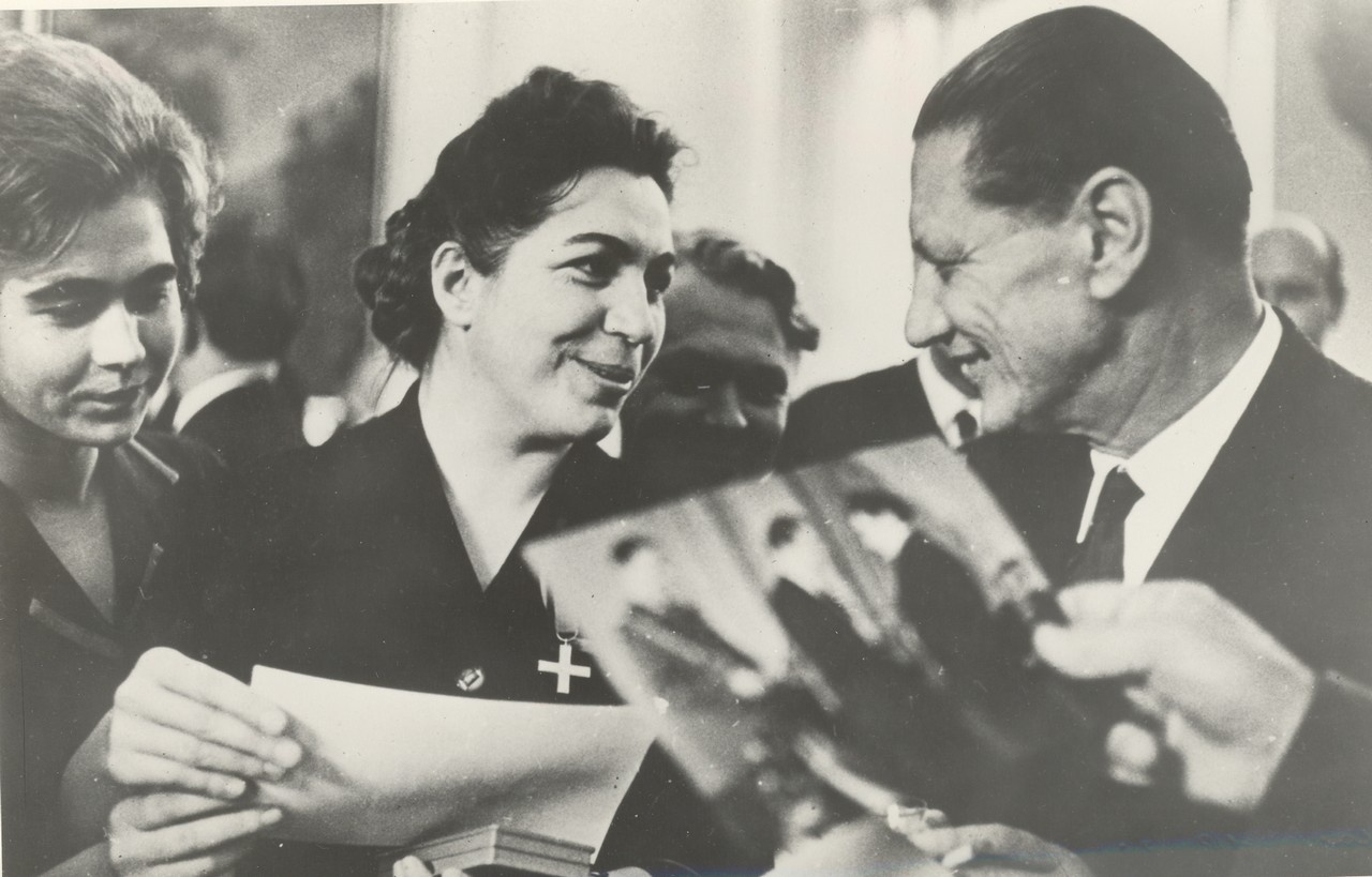 Посол Польши Э. Пщулковский (справа) поздравляет радистку А. Анисимову (вторая справа) с награждением её орденом «Партизанский Крест». 1964 год.