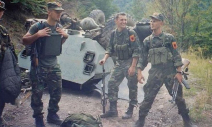 Боевики ОАК стоят рядом с уничтоженным сербским БТР.