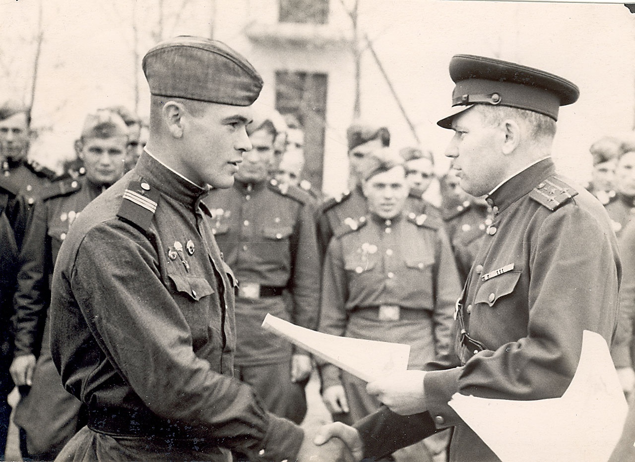 Командир десантного полка полковник Александр Лазаренко вручает грамоту отличившемуся сержанту.