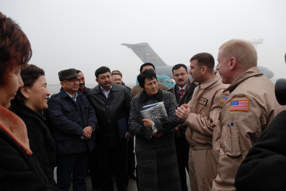 Командир 376-го авиационного экспедиционного крыла полковник Кристофер Бенс приветствует члена парламента Кыргызстана на брифинге миссии во время визита на авиабазе Манас.