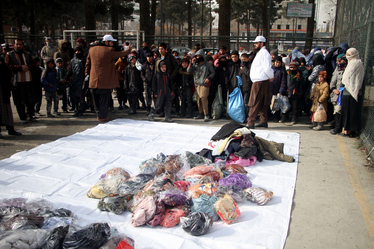 Дети выстраиваются в очередь, чтобы получить одежду, раздаваемую некоммерческой организацией в Кабуле.