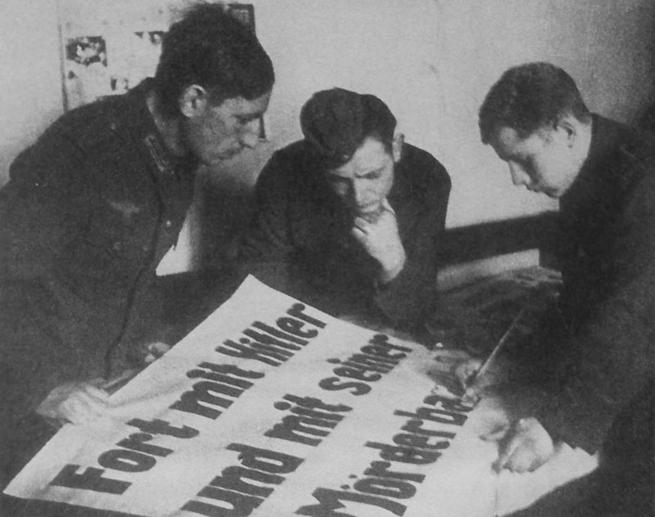 Военнопленные готовят агитплакат в лагере. Надпись на плакате - «Долой Гитлера и его банду убийц!».