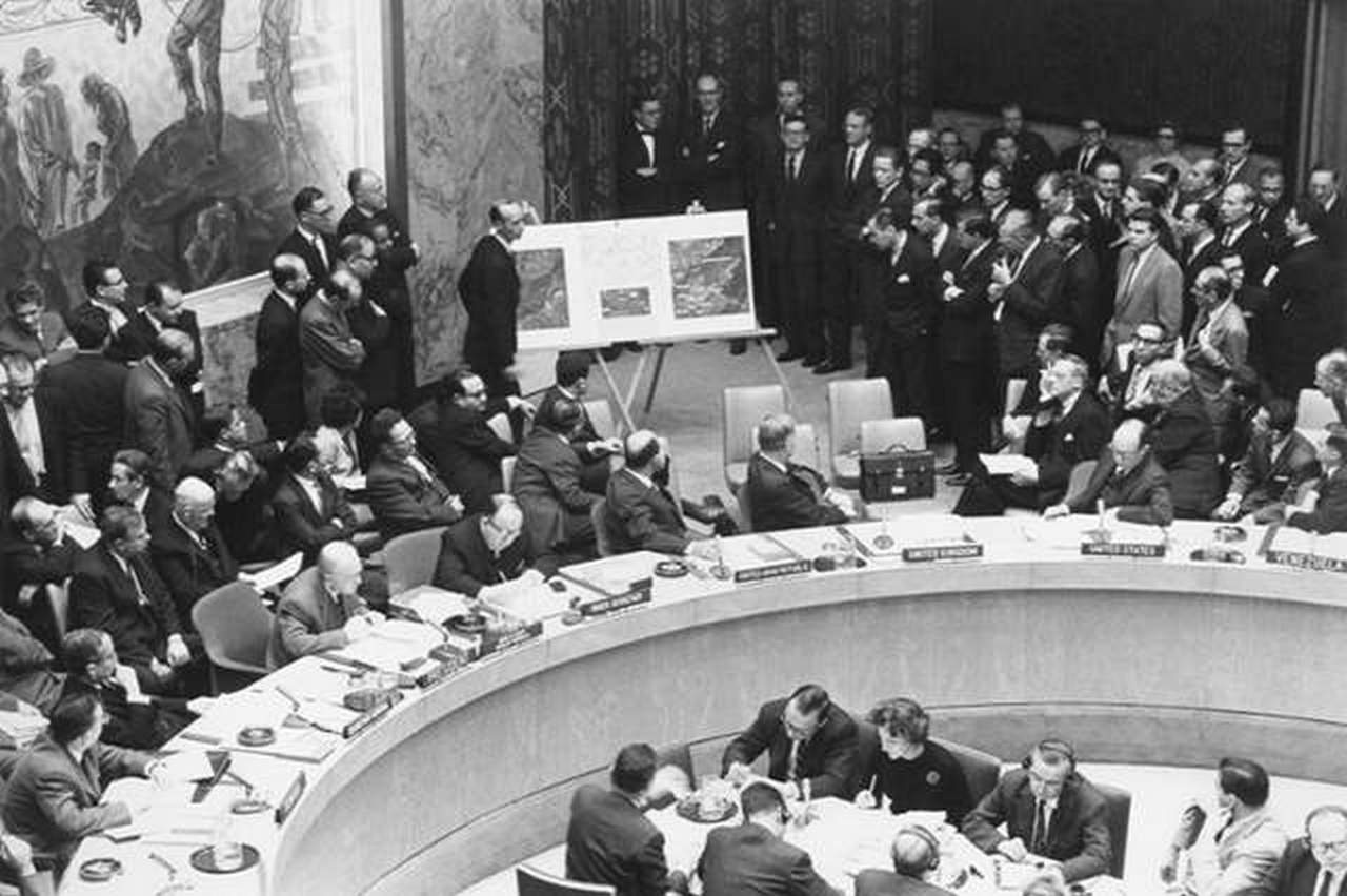 Постоянный представитель США Эдлай Стивенсон демонстрирует Совету Безопасности ООН аэрофотоснимки пусковых установок советских ракет на Кубе.