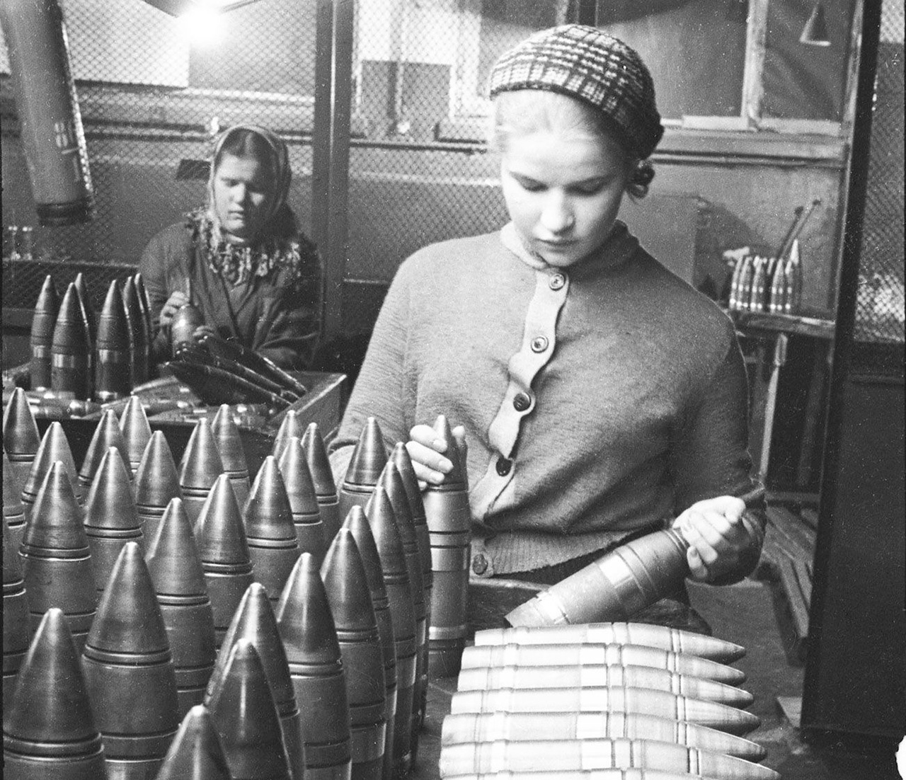 Приемщица Байбакова за проверкой 76-мм бронебойных снарядов. 1941-1942 гг.