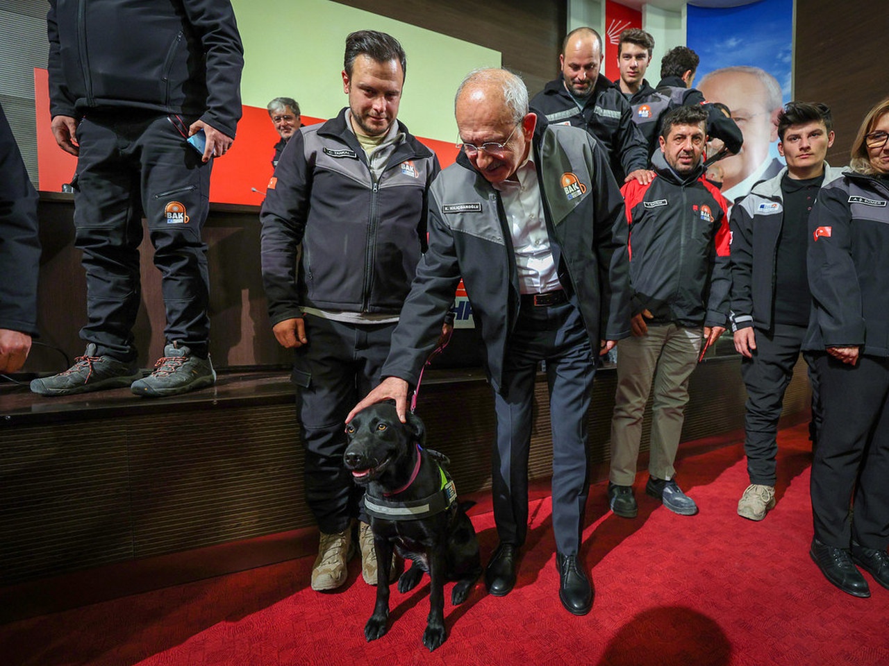 Кемаль Киличдароглу (в центре с поисковой собакой) встретился с группой спасателей, которая работала в Хатае, 17 февраля 2023 г.