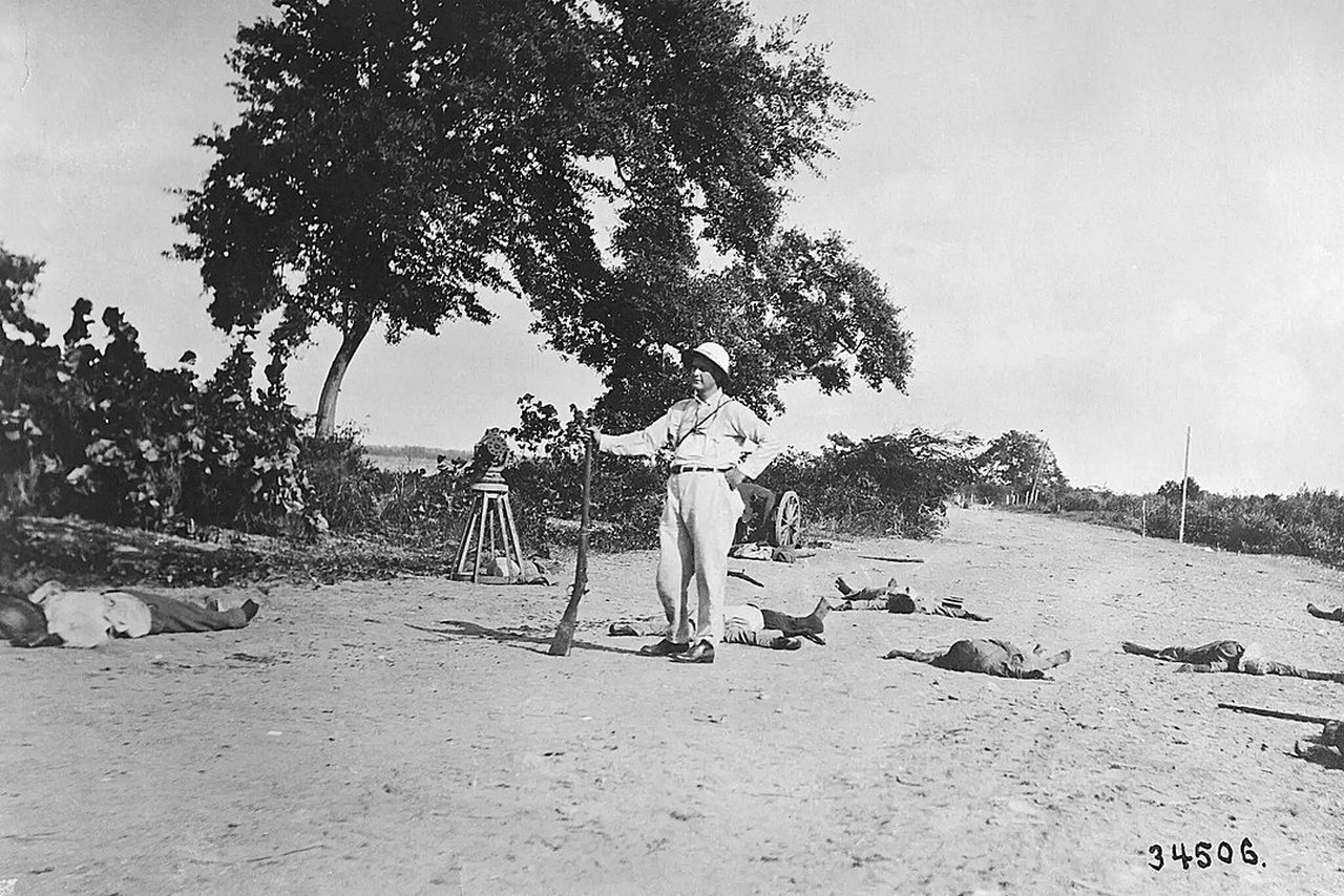 Американец позирует с мёртвыми гаитянами, убитыми пулемётным огнём морской пехоты США, 11 октября 1915 г.