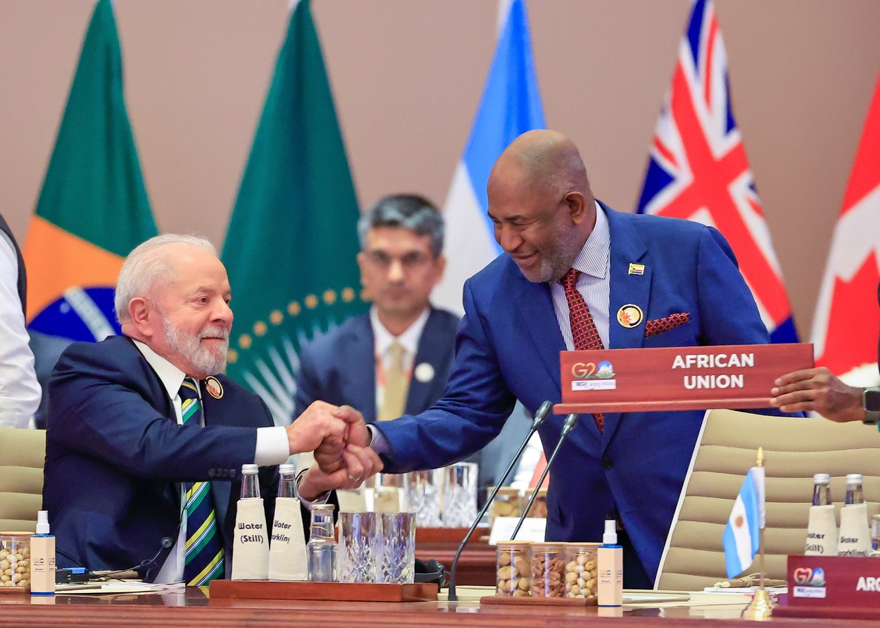 Президент Бразилии Лула да Силва (слева) поздравляет председателя Африканского союза Азали Ассумани (справа) после того, как организация стала постоянным членом «Большой двадцатки».