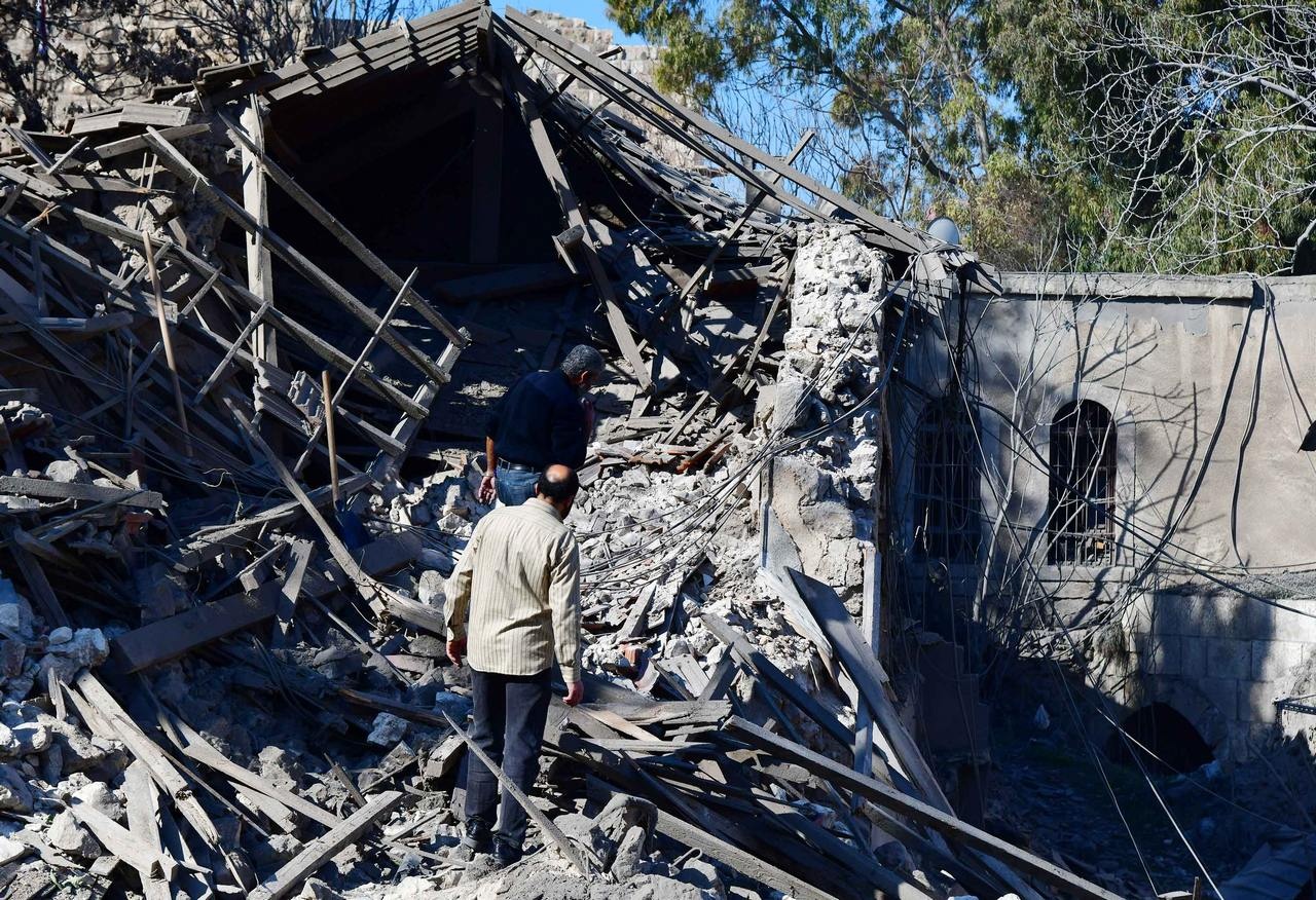 Люди осматривают ущерб, нанесённый израильским ракетным ударом внутри исторической цитадели Дамаска, февраль 2023 г.