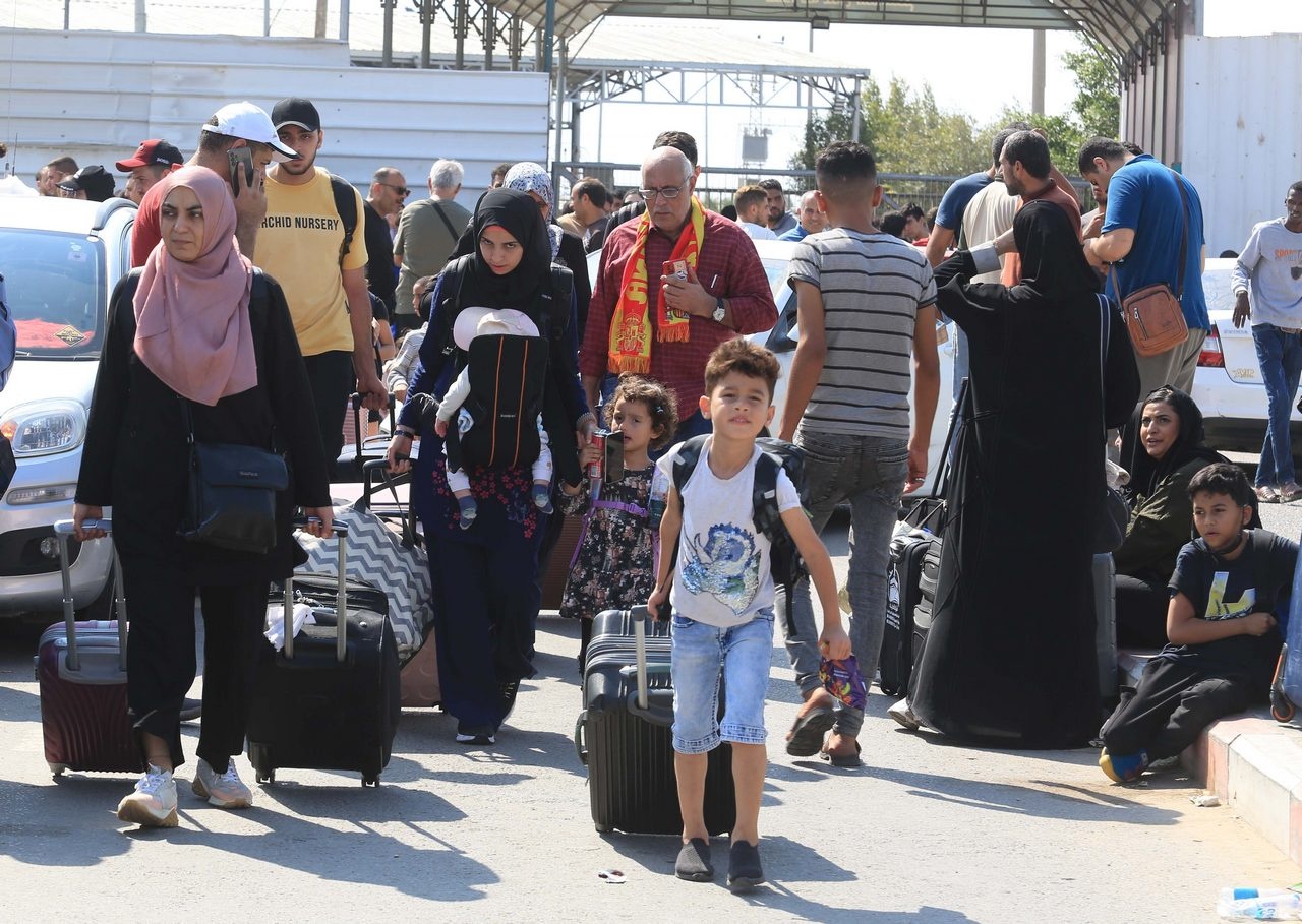 Семьи с детьми ждут на пограничном переходе Рафах между сектором Газа и Египтом.
