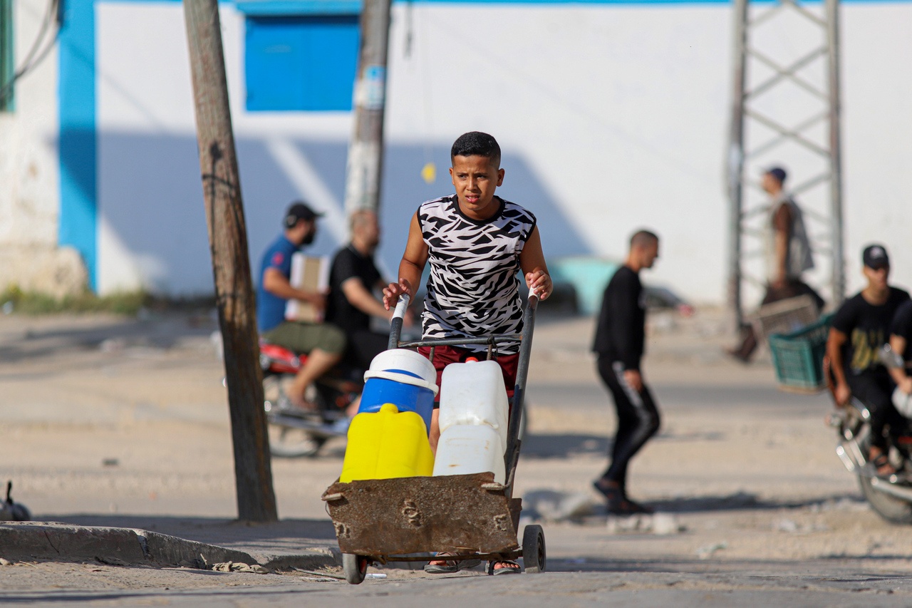 Палестинский юноша везёт воду в городе Хан-Юнис на юге сектора Газа, 18 октября 2023 г.