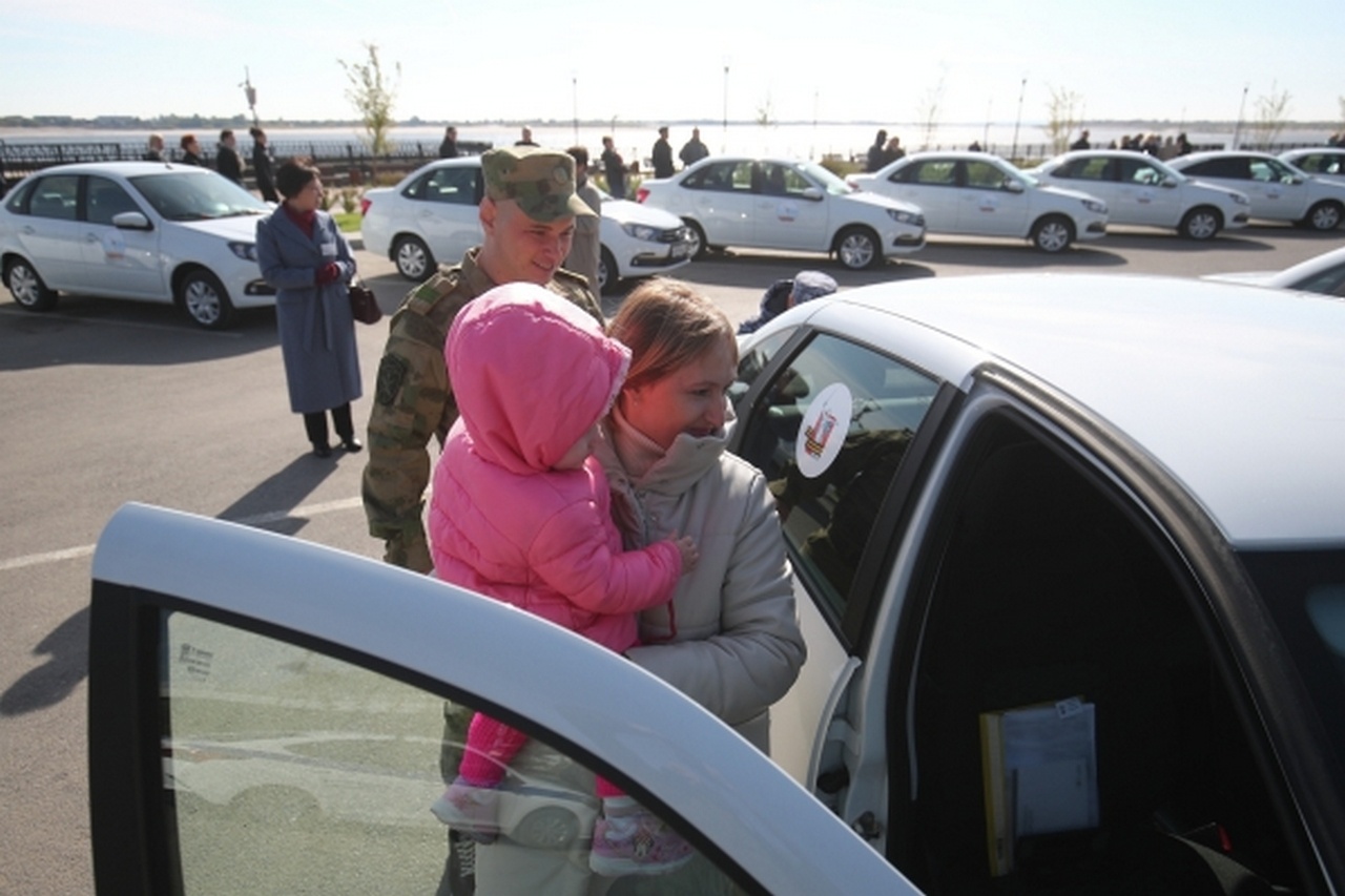 Военный с семьёй у нового автомобиля Lada, переданного участникам СВО и ветеранам боевых действий в Волгограде.