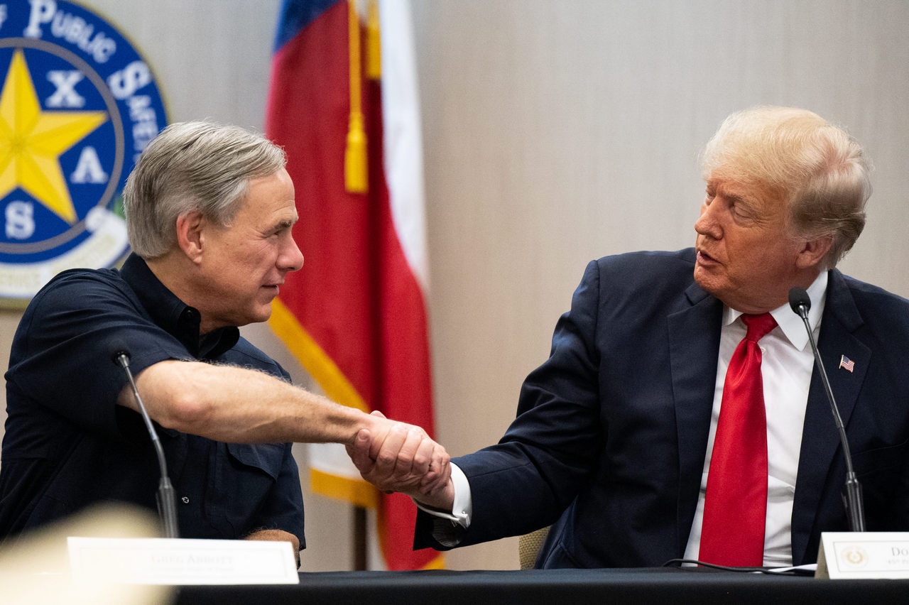 Губернатор Техаса Грег Эбботт и экс-президент США Дональд Трамп пожимают друг другу руки во время брифинга по пограничной безопасности, 30 июня 2021 г.
