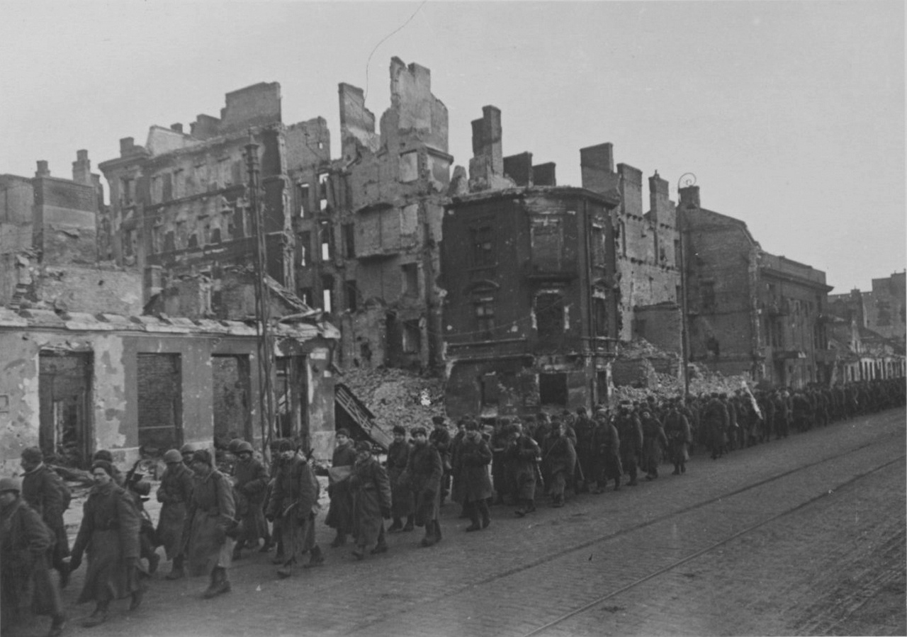 Колонна советских солдат на марше по разрушенной улице Варшавы.