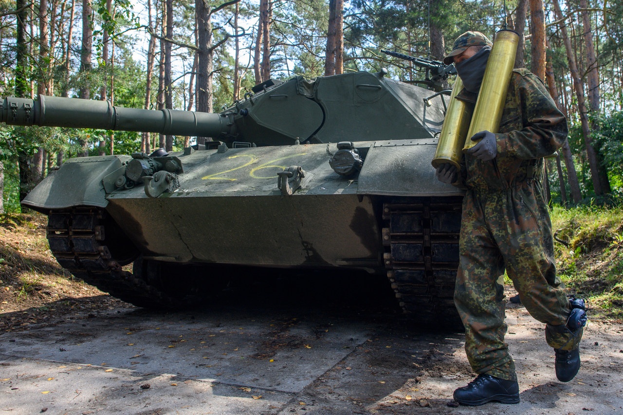 Украинский солдат выгружает гильзы от боеприпасов из танка Leopard 1 A5 на полигоне в Германии.