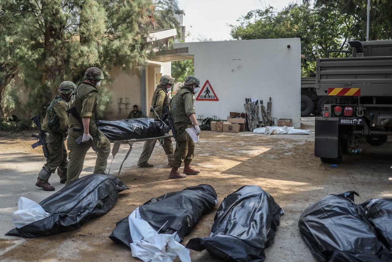 Военнослужащие собирают тела в одном из израильских поселений, пострадавших от атаки, 10 октября 2023 г.
