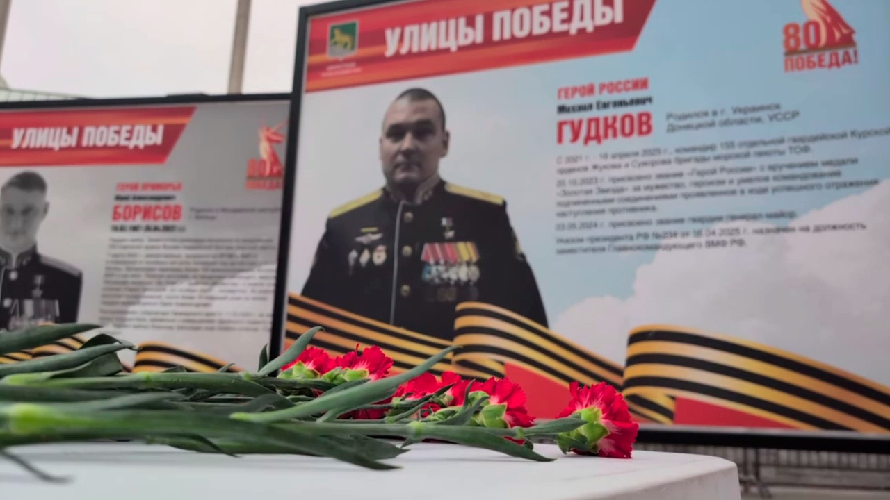 Люди несут цветы к табличке с именем Михаила Гудкова во Владивостоке 